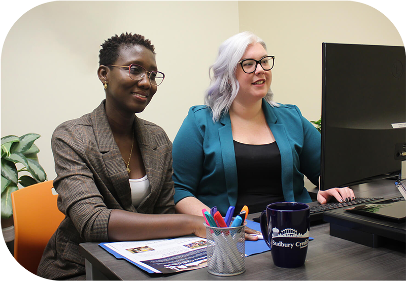 Two SCU employees working at a computer together.