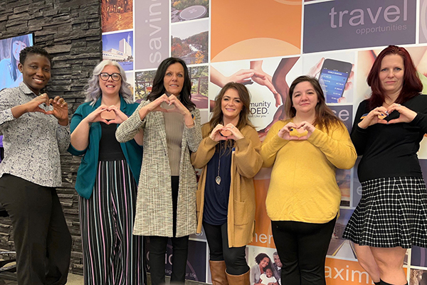 SCU branch staff making hearts with their hands.