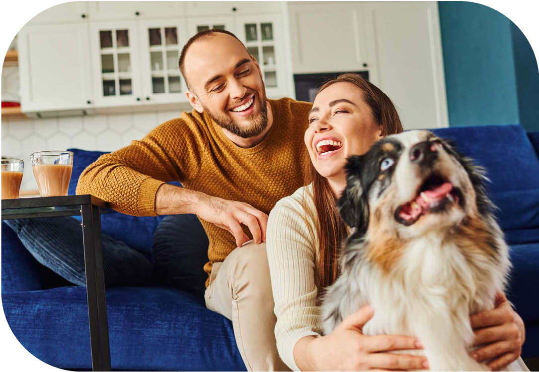 Couple sitting on the couch with their dog. 